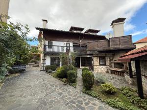 a house with a stone walkway in front of it at White Wolf Chalet in Bansko