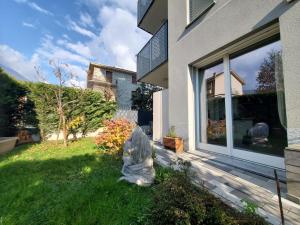 a statue sitting in the grass next to a house at Appartamento La Camelia in Sondrio