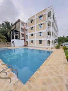 a large swimming pool in front of a building at Diani Beach Modern Apartment in Diani Beach