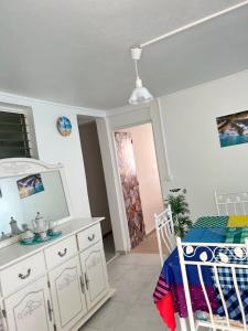 a room with a bed and a dresser and a door at Dolce Vita Emilia in Sainte-Luce