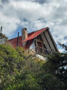 a house with a red roof on top of a hill at Hotel Campestre los Duraznos in Cucunubá