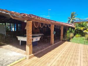 a pavilion with a ping pong table on a deck at Pousada Taba de Canes in Canavieiras