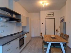 a kitchen with a wooden table and a dining room at Appartamento La Camelia in Sondrio