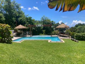 a swimming pool in a yard with grass at forst home with a great ocean view in Kingstown