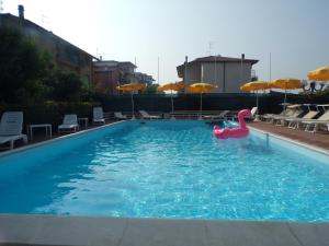 a swimming pool with a pink swan in the water at Hotel Crystal con Piscina Estiva Privata - SPIAGGIA INCLUSA con Formula All Inclusive 7 notti in Rimini