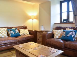 a living room with two couches and a coffee table at Oaktree Cottage-Uk42227 in Low Borrowbridge