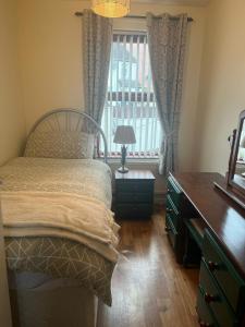 a bedroom with a bed and a desk and a window at Cierons château in Derry Londonderry