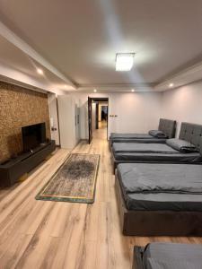 a room with four beds and a flat screen tv at Casa Boitor in Jidvei