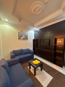 a living room with a blue couch and a table at جميــرا لاين in Abha