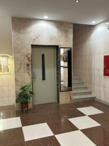a hallway with a door and stairs in a building at جميــرا لاين in Abha