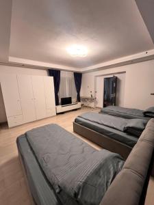 a room with three beds and a couch in it at Casa Boitor in Jidvei