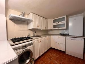 a kitchen with white cabinets and a stove top oven at Casa Boitor in Jidvei