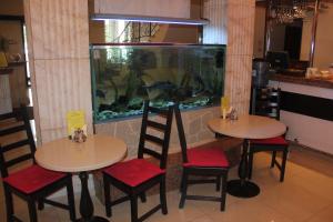 two tables and chairs in a restaurant with an aquarium at Cron Hotel in Moscow