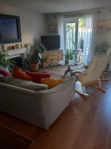 a living room with a couch and chairs and a television at Beautiful detached home in Evesham