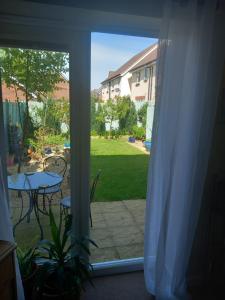 an open door to a patio with a table and chairs at Beautiful detached home in Evesham