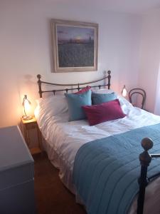 a bedroom with a bed with blue and red pillows at Beautiful detached home in Evesham