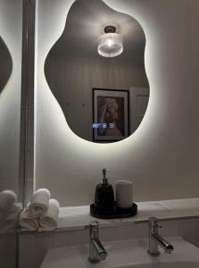 a bathroom with a mirror over a sink and a sink at Entire Flat in Lichfield City Centre in Lichfield