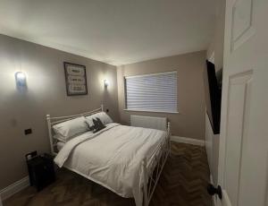 a bedroom with a white bed with a window at Entire Flat in Lichfield City Centre in Lichfield