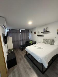 a bedroom with a bed and a living room at Rooms Capulino in Málaga