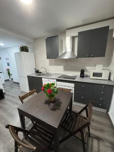 a kitchen with a wooden table with flowers on it at Rooms Capulino in Málaga