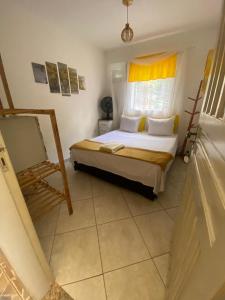 a bedroom with a bed and a window and a mirror at Suítes no centro Histórico Diamantina in Diamantina