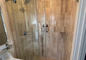a shower with a glass door in a bathroom at Rochambeau Roadside Inn in Williamsburg +32 photos