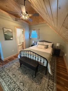 a bedroom with a bed and a ceiling fan at Cattail Cabin in Waterville