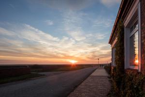 un camino vacío con la puesta de sol en el fondo en Haus Nordland en Juist