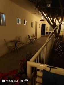 a balcony with a table and chairs and a tree at El Cubanito Cafe y hospedaje in León