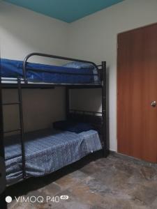 a room with two bunk beds and a door at El Cubanito Cafe y hospedaje in León