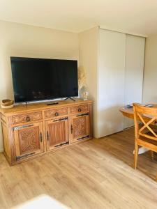 a flat screen tv sitting on top of a wooden cabinet at Le Fort Vauban in Ambleteuse