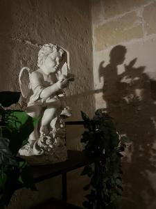 a statue of a cherub holding a cell phone at ITALY Home 16 in Grottaglie