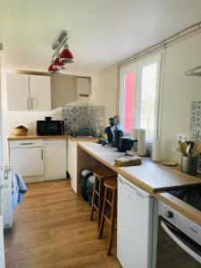 a kitchen with white cabinets and a wooden counter top at Le Fort Vauban in Ambleteuse
