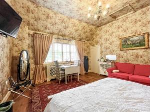 a bedroom with a bed and a red couch and a desk at Cottage 2 - Uk46612 in Broughton