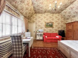 a living room with a red chair and a table at Cottage 2 - Uk46612 in Broughton
