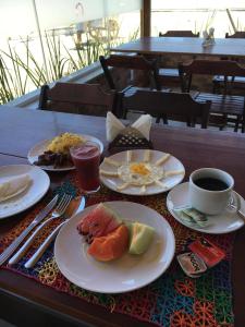 a table with plates of food and a cup of coffee at Le Soleil Pousada e Restaurante in Praia do Frances