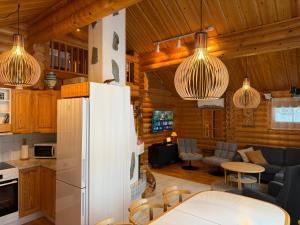 a kitchen and living room in a log cabin at Villa Rukan Honka in Ruka
