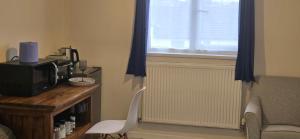 a room with a desk with a chair and a window at Town Centre Studio with Ensuite in Aylesbury