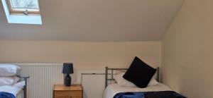 a bedroom with a bed with a black pillow on it at Town Centre Studio with Ensuite in Aylesbury +3 photos