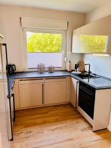 a kitchen with a stove and a window at CozyHome mit Netflix, voll ausgestatteter Küche, Zentrums- und Bahnhofsnah, Balkon, self-Check-in möglich in Bückeburg