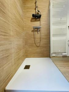 a shower with a hose in a wooden bathroom at Les oiseaux de la Slack in Ambleteuse +10 photos