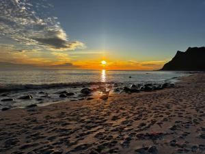 a sunset on a beach with the sun setting at 2 beds apartment centrally located in Gravdal in Gravdal