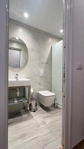 a bathroom with a sink and a toilet and a mirror at VANGJELIS HOTEL in Himare +124 photos