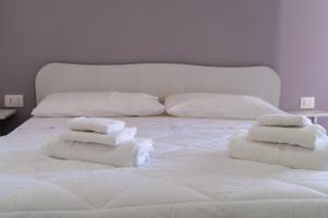 a white bed with towels on top of it at Mulino Suites in Scalea