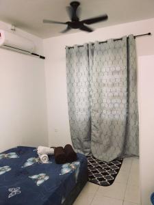 a bedroom with a bed with a ceiling fan at HAIZRINA HOMESTAy in Sungai Petani