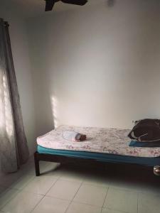 a bed in a room next to a wall at HAIZRINA HOMESTAy in Sungai Petani