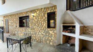 a stone wall with a table and chairs on a patio at Casa Angel 3 in Castril