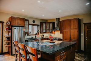 a kitchen with a counter and a refrigerator at Big Bear Chalet and spa in Revelstoke
