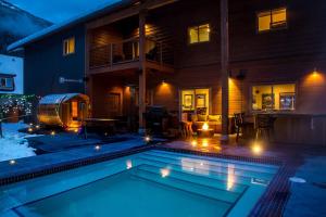 a swimming pool in front of a house at night at Big Bear Chalet and spa in Revelstoke
