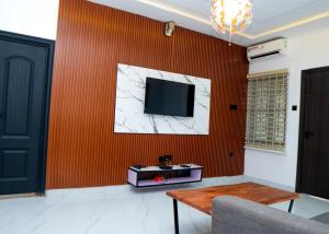 a living room with a tv on a red wall at Riverside Nest Owerri LTD in Owerri